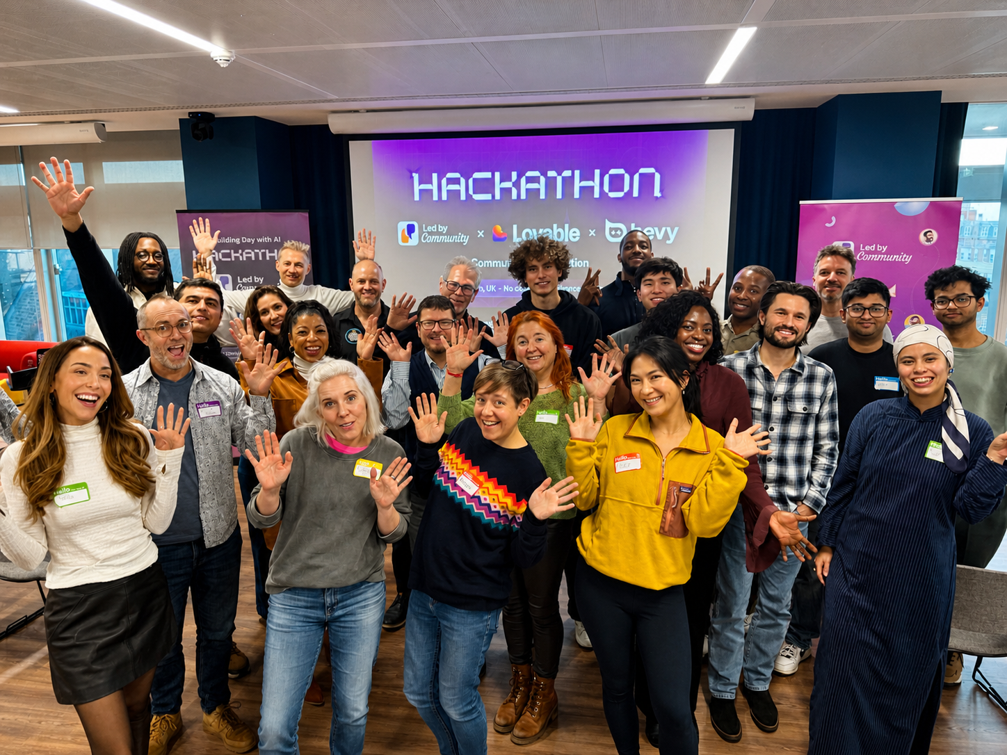 Led by Community members waving at a hackathon in London